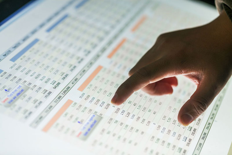 hand pointing at business financials chart on screen